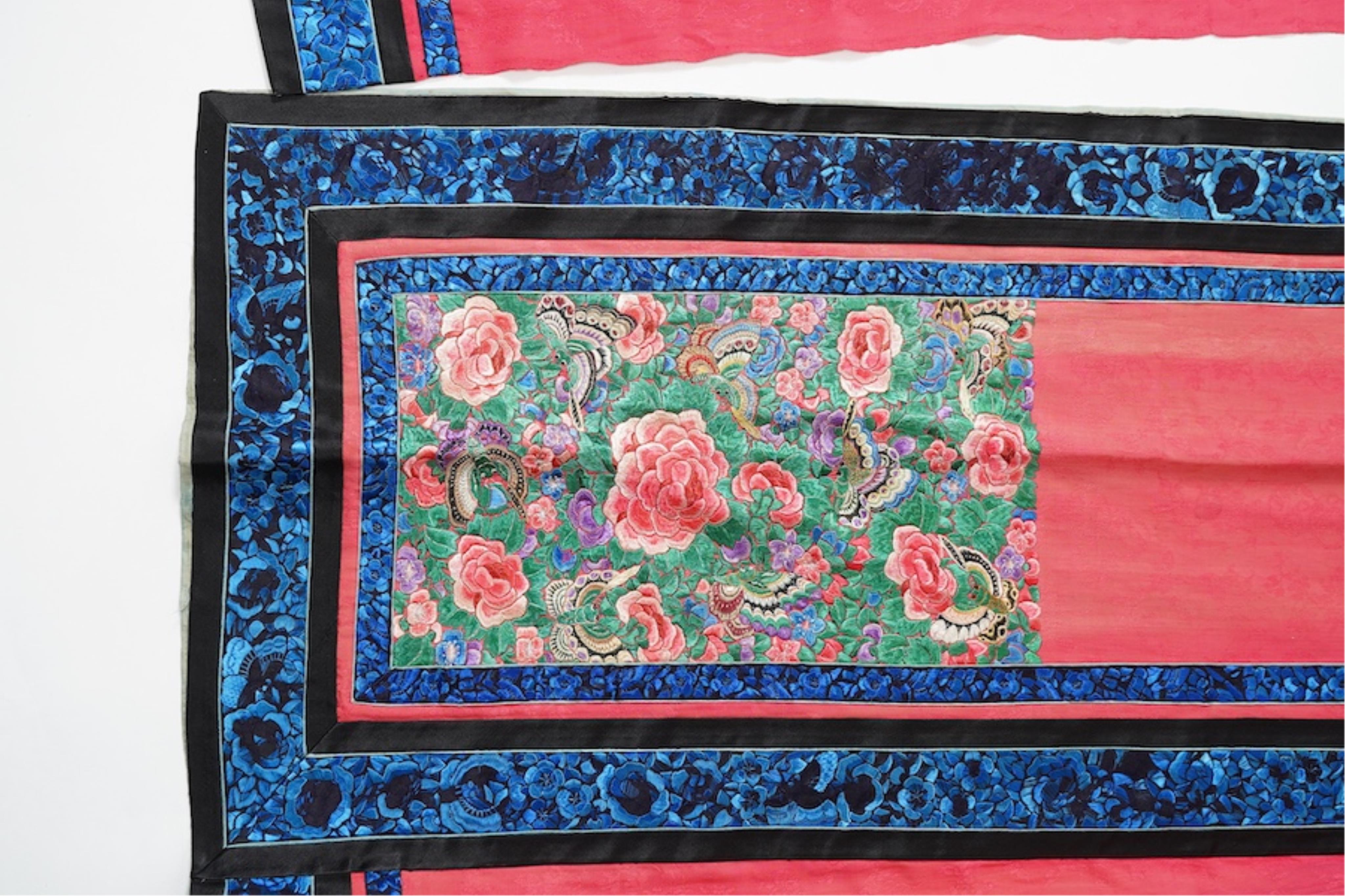 Two late 19th early 20th century Chinese wedding skirts. Made with pink silk damask, embroidered with large decorative silk floral and butterfly front panels bordered by blue embroidered black silk borders between pleats